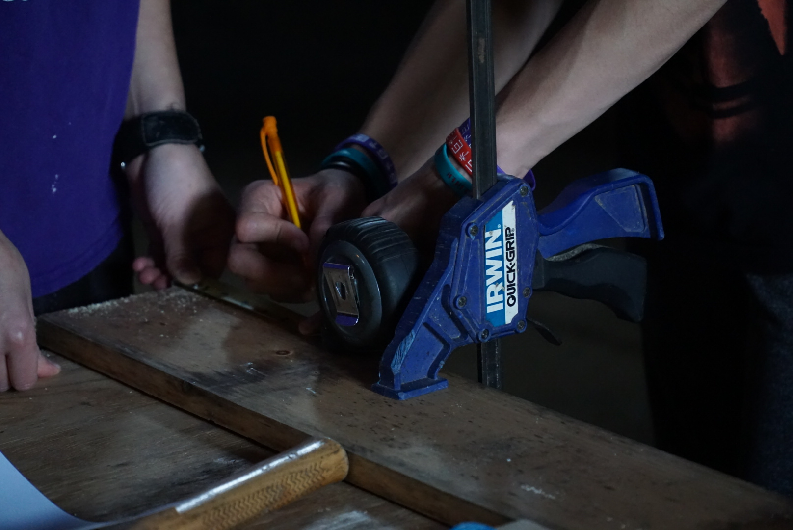 An image of someone marking a measurement on a piece of wood before they cut it with the saw.